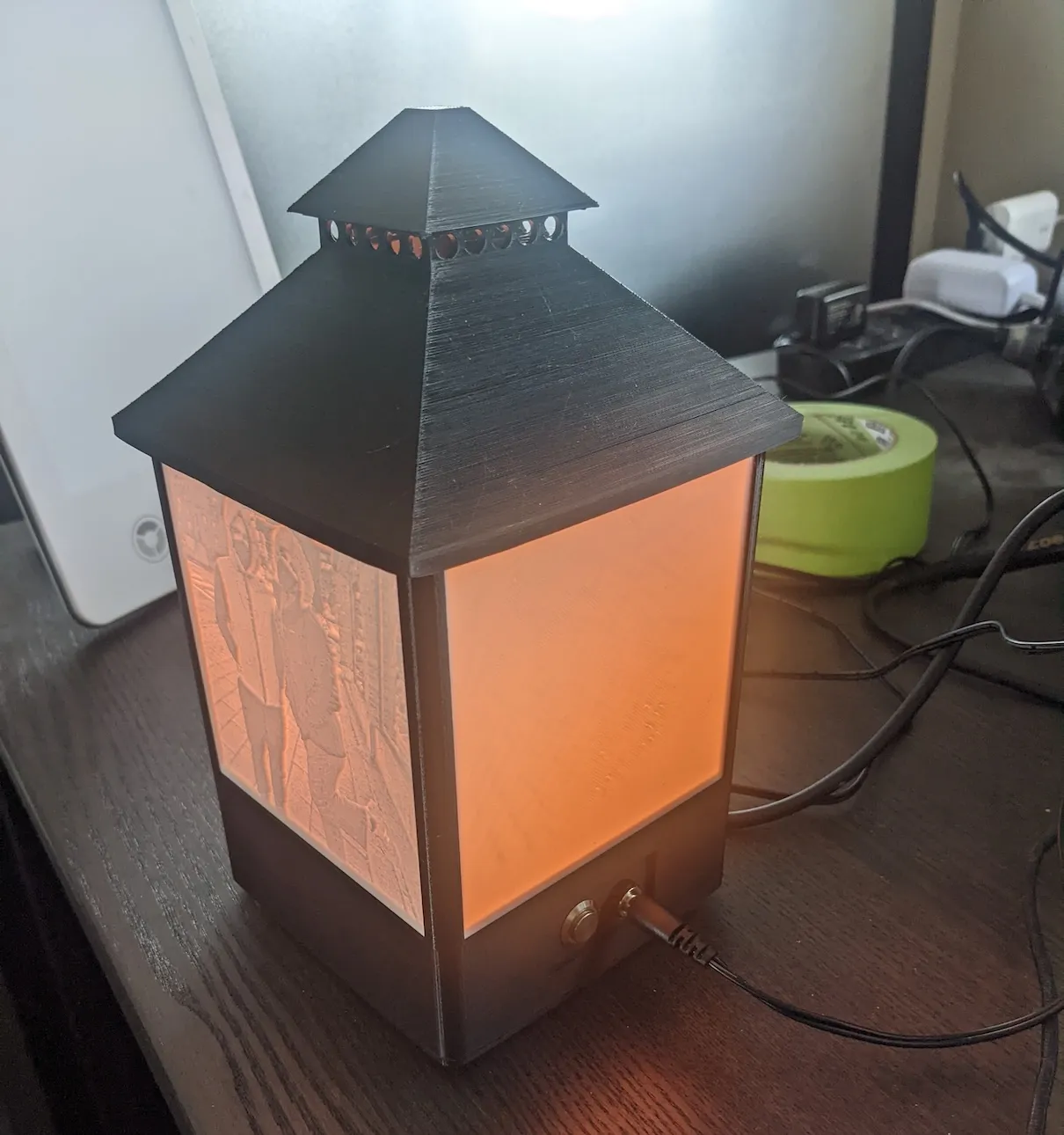 Completed lithophane photo lantern glowing on a desk